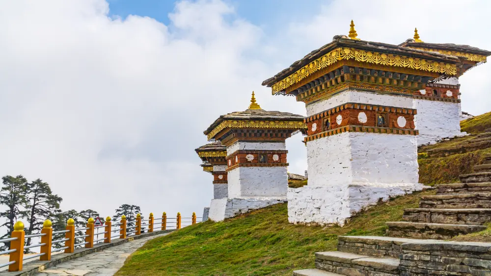 White memorial chortens with golden spires on the hillside at Dochula Pass, Bhutan