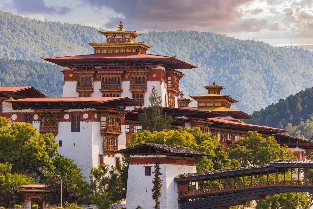 Rinpung Dzong in Paro with carved wooden windows and tiered red roofs against forested hills