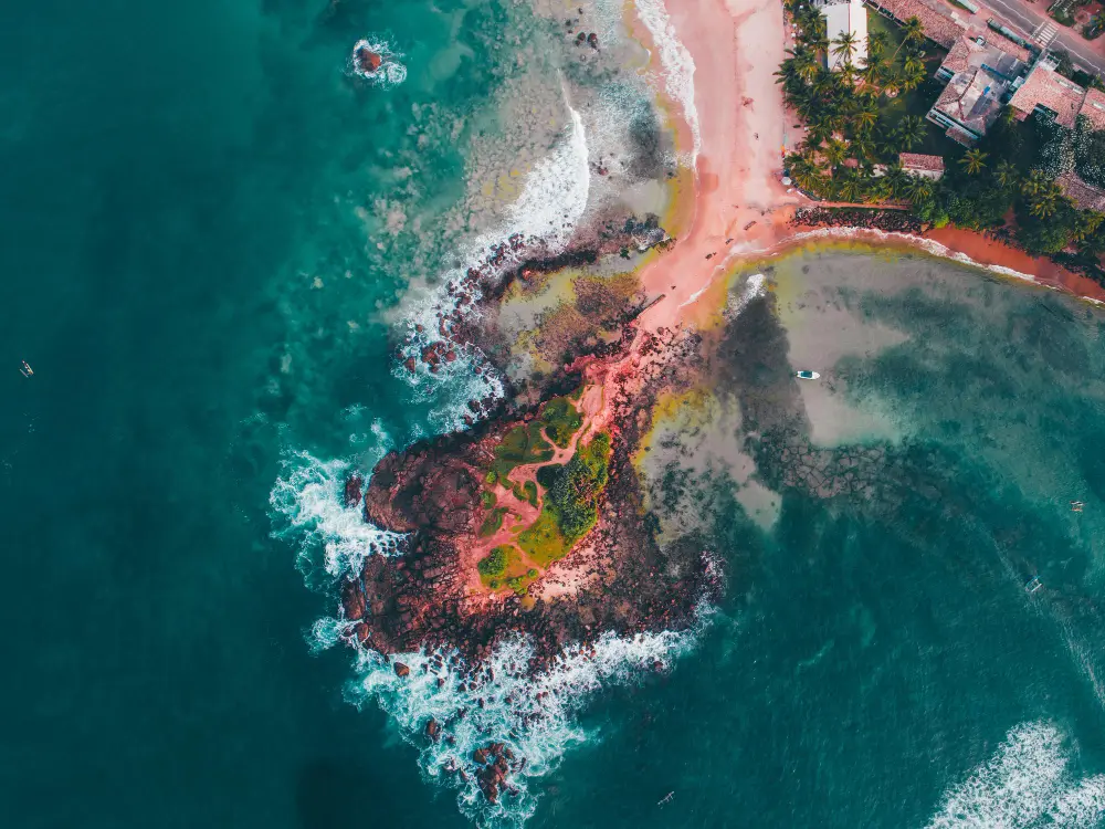 Aerial view of a rocky coastline and turquoise sea in Sri Lanka
