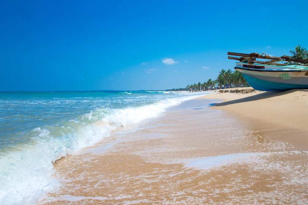 Fishing boat on a golden sand beach on the Sri Lankan coast