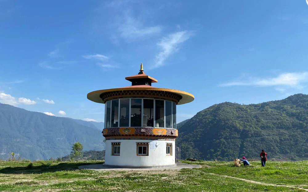 Ta Dzong National Museum of Bhutan tower with a golden pagoda roof set against green mountains in Bhutan